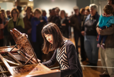 woman playing the piano at an art opening