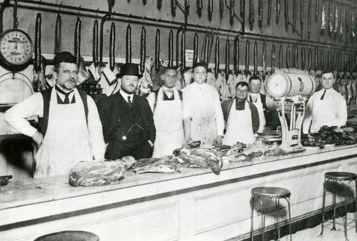A group of kosher butchers standing behind a counter.