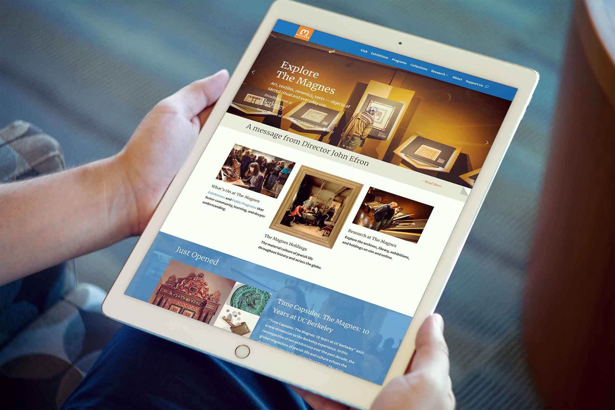 person holding an iPad showing the new Magnes website