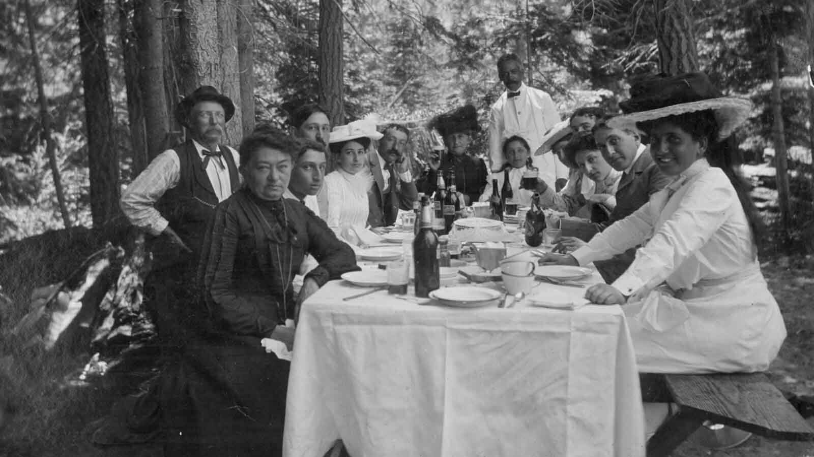 family sitting around a table in a redwood forest.